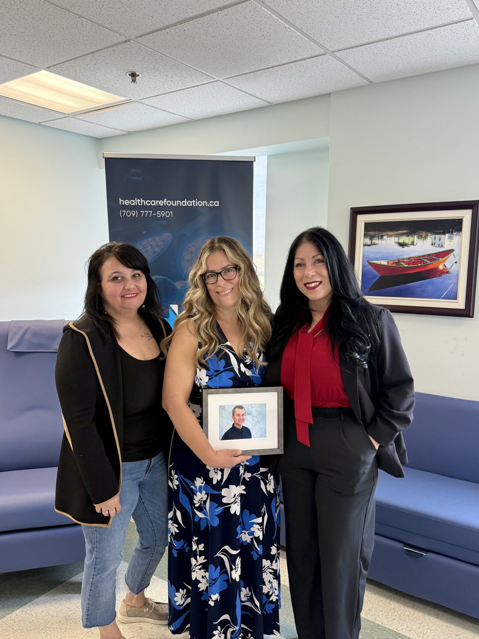 Family holding a framed photo in a palliative care family room