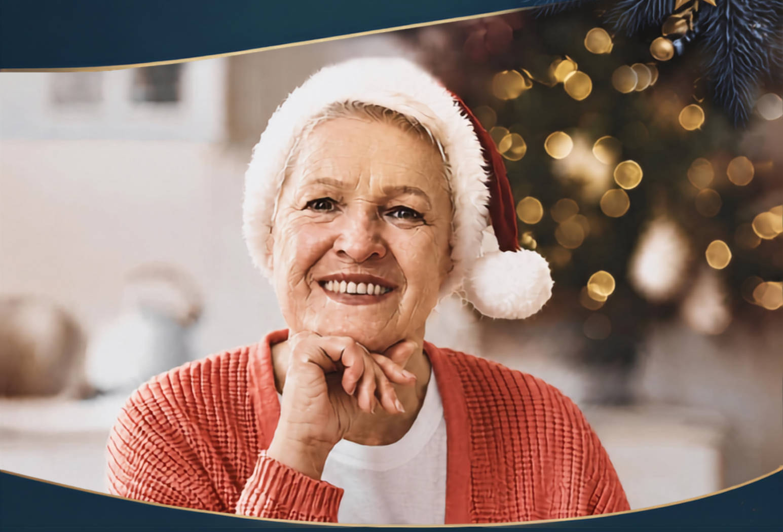 Smiling senior woman wearing a Santa hat beside a Christmas tree