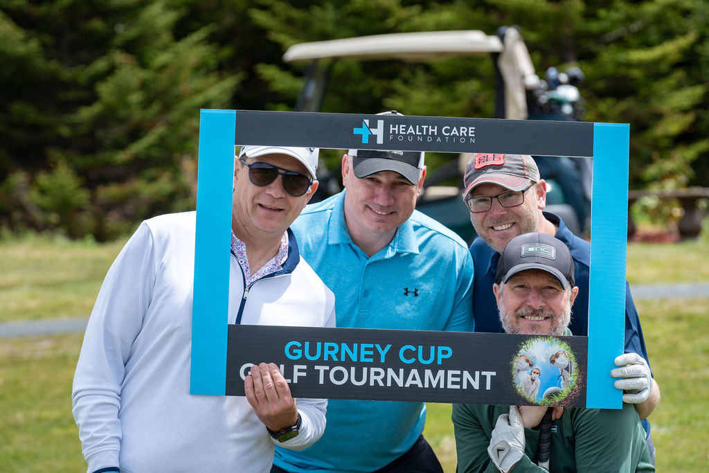Golfers posing with a photo frame on the course at the 2026 Gurney Cup Golf Tournament