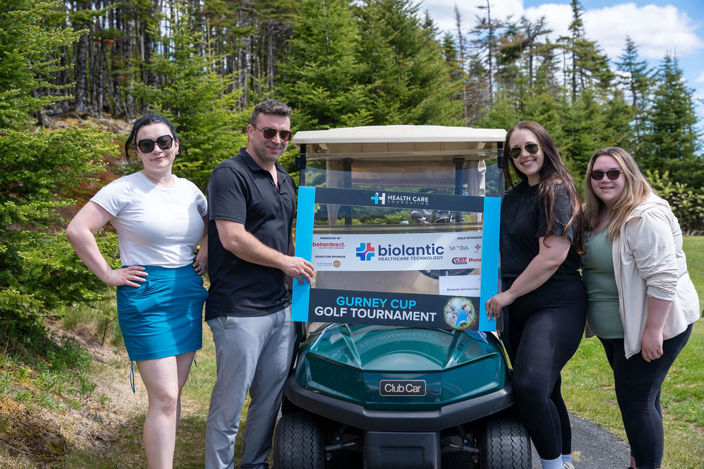 Golfers posing beside a golf cart at the 2026 Gurney Cup Golf Tournament