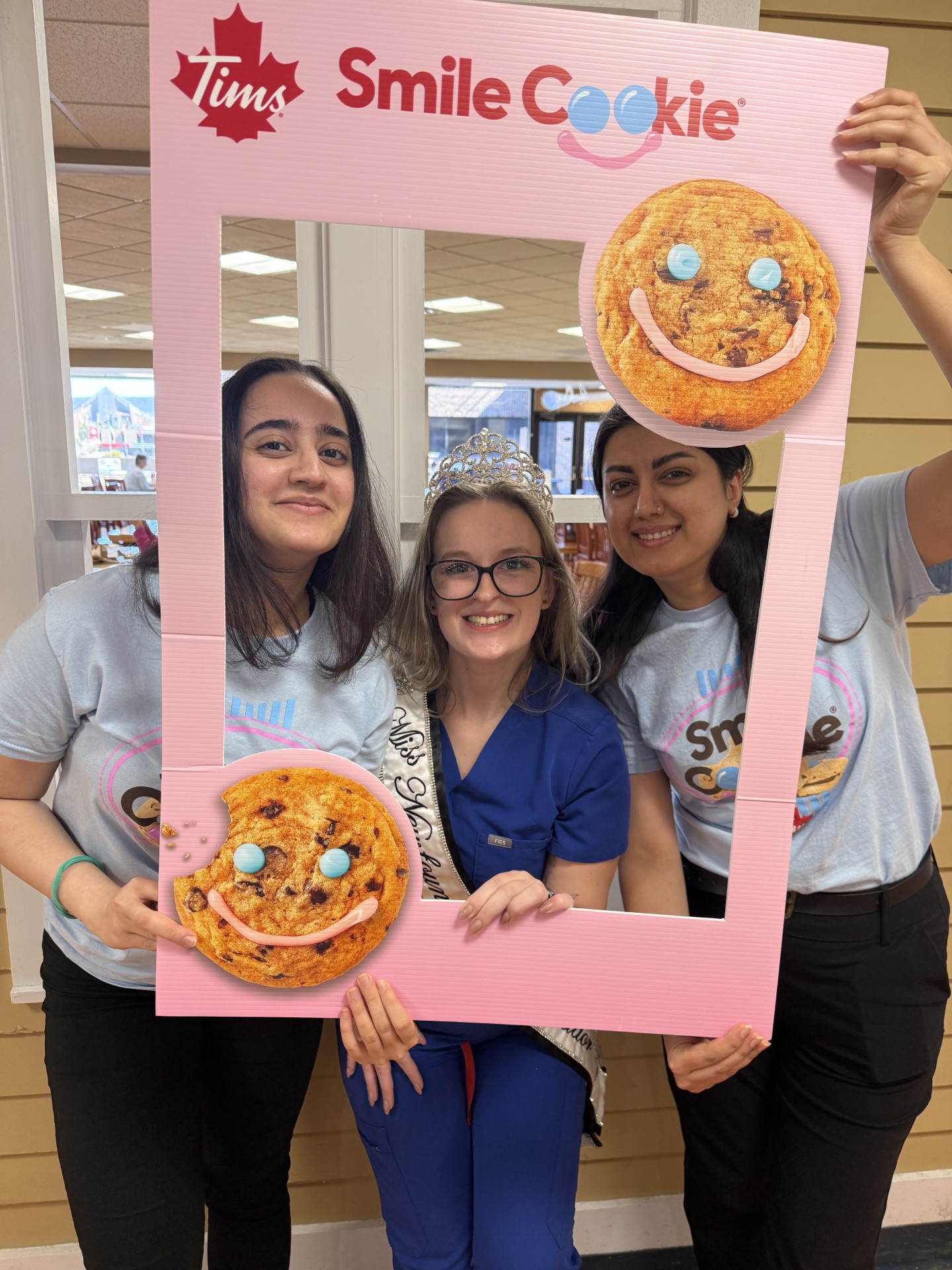 Volunteers posing with a Smile Cookie photo frame