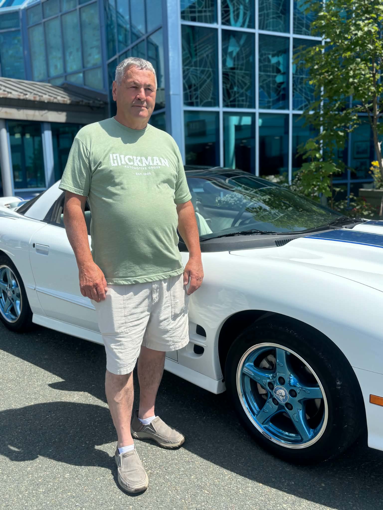 Participant standing beside a white classic car at a Health Care Foundation car show