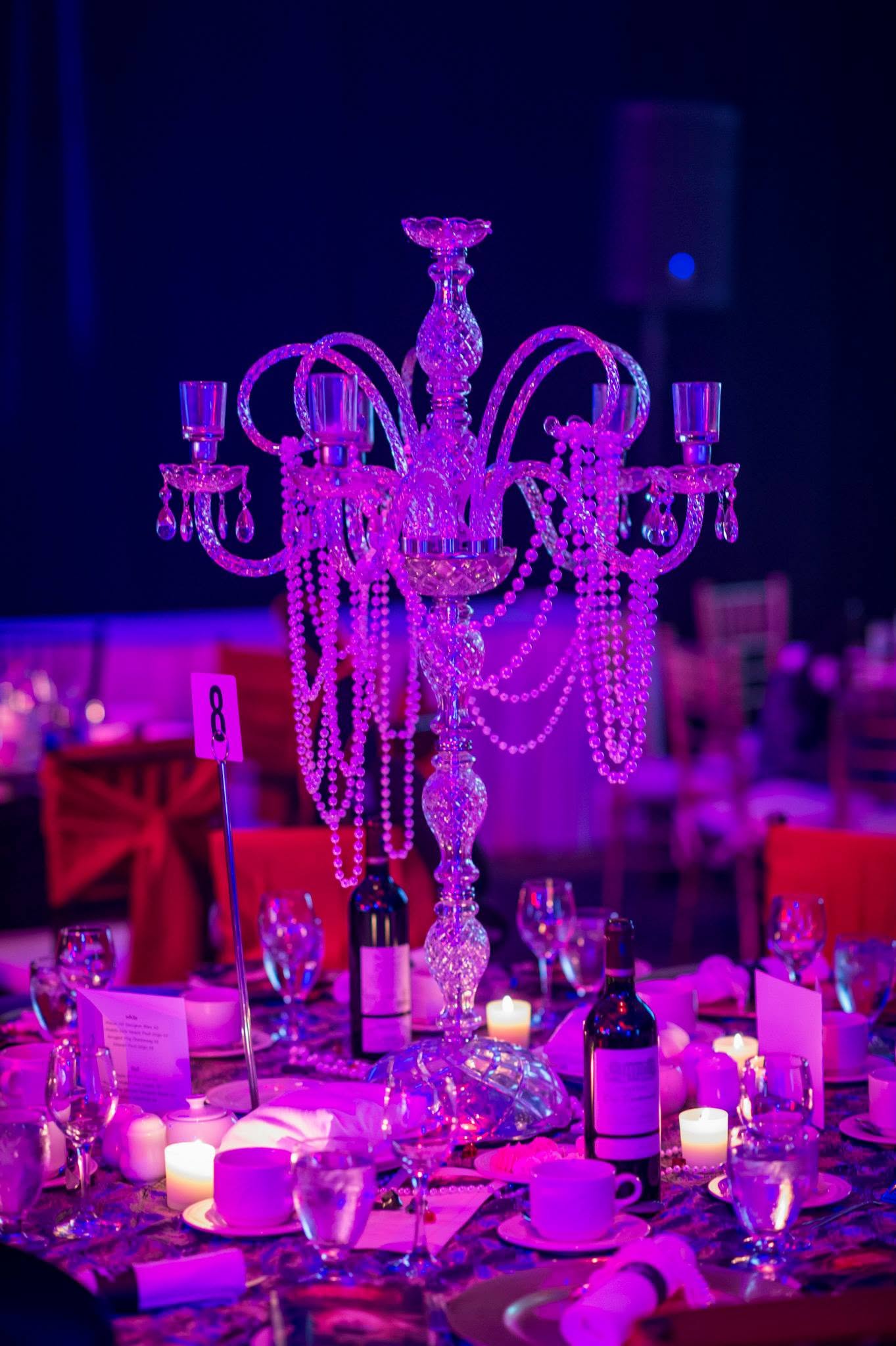 Purple-lit chandelier and table décor at a Health Care Foundation gala