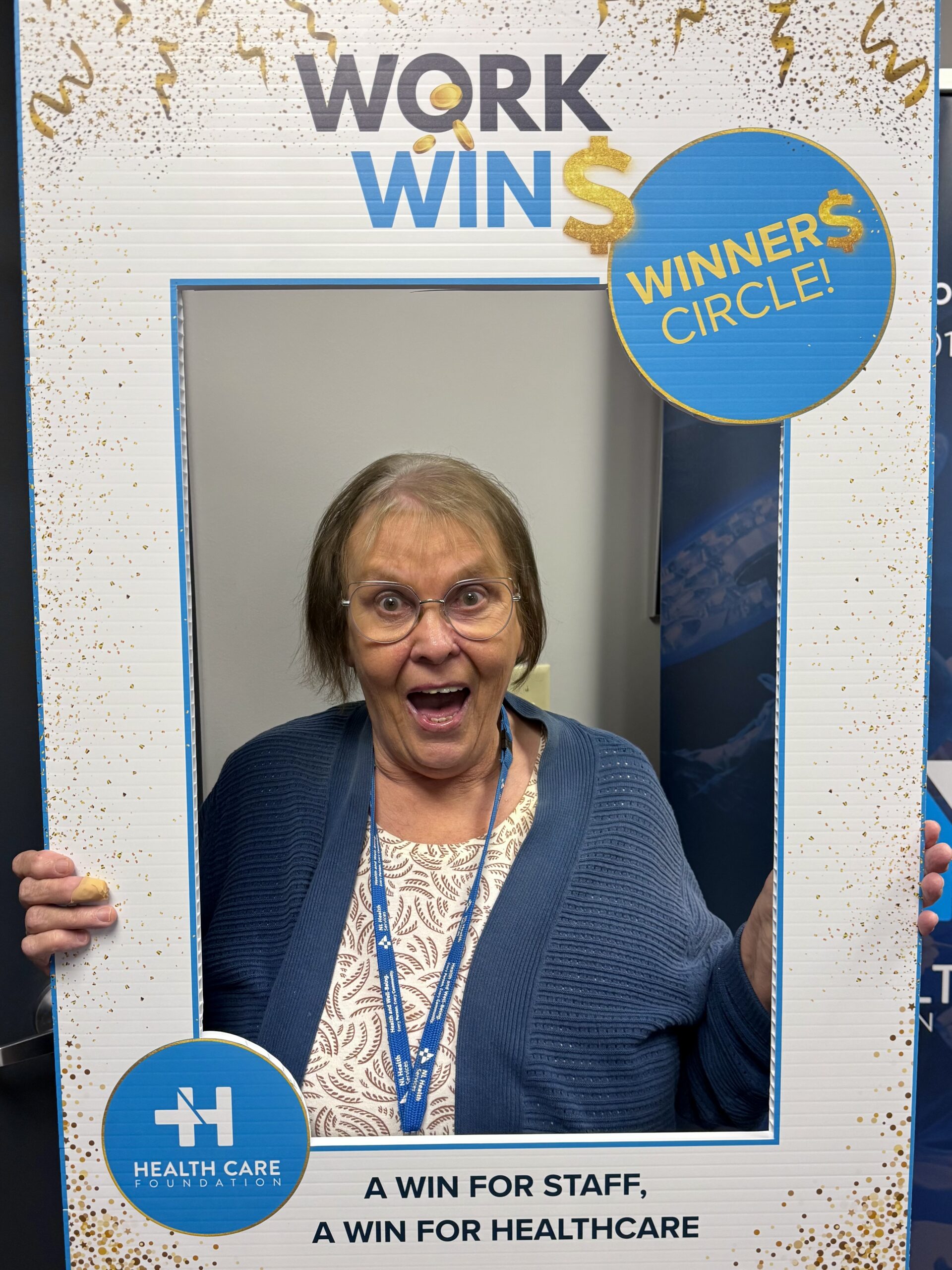 Carol Ann Evans posing with a Work Wins photo frame