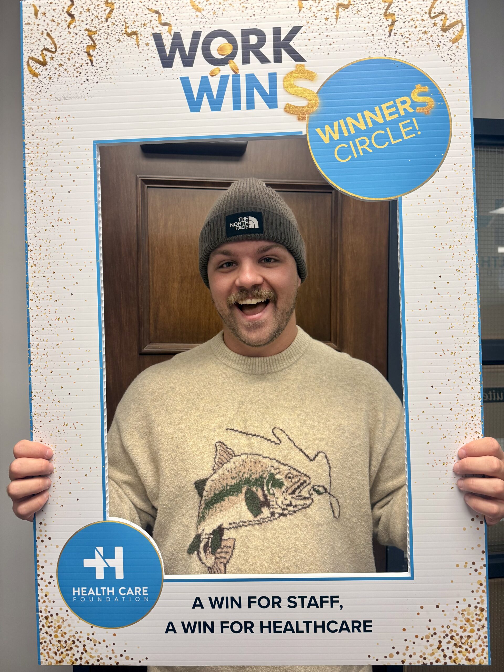 NL Health Services staff member posing with a Work Wins photo frame