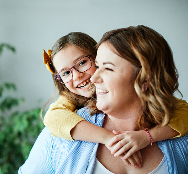 Smiling mother hugging her young daughter