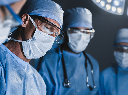 Surgeons wearing masks and caps in an operating room