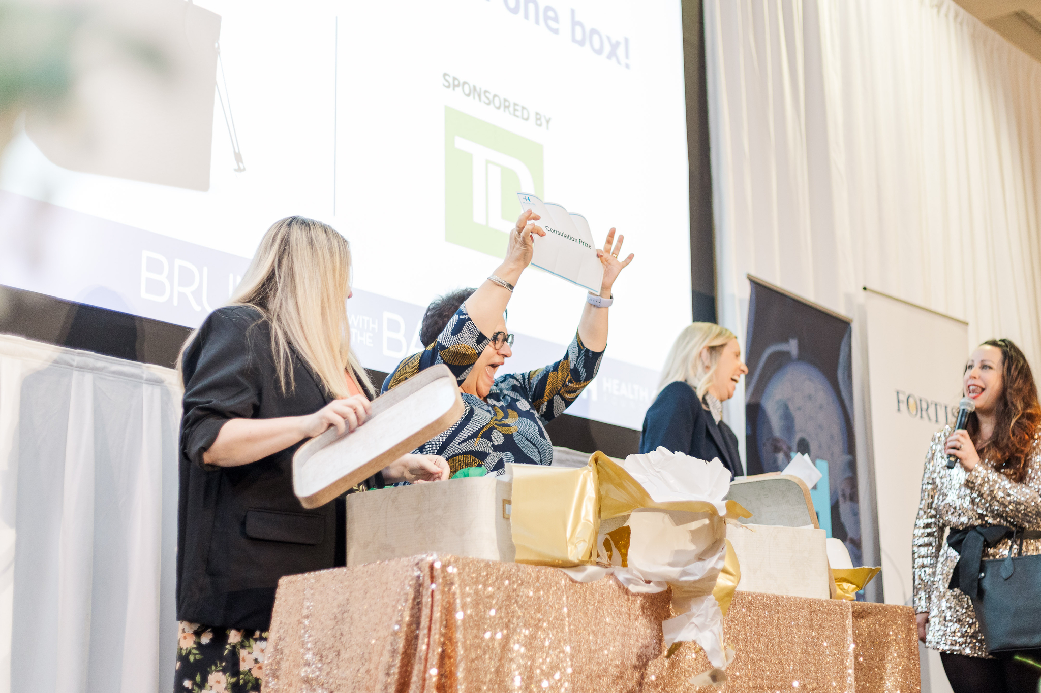 Guests holding up designer handbags at Brunch with the Bags