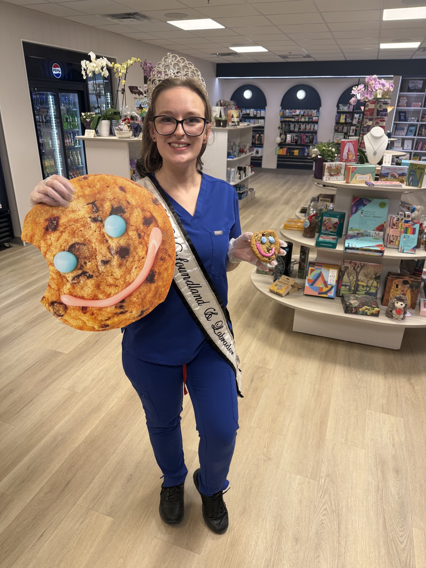 Volunteer holding a giant Smile Cookie in a store