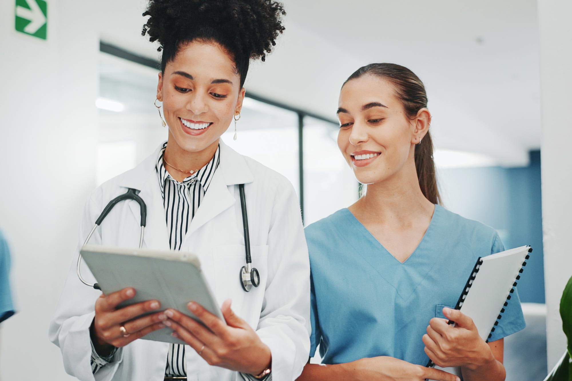 Two health care workers reviewing information on a tablet