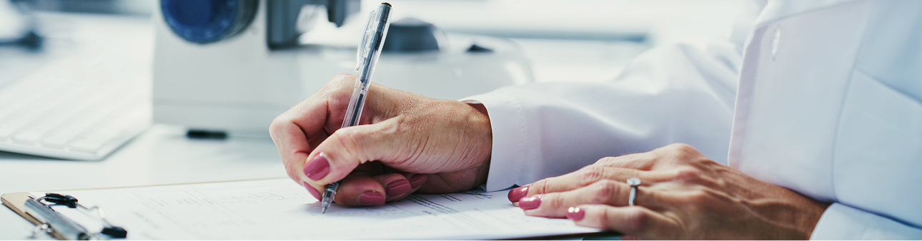 Person signing a document at a desk
